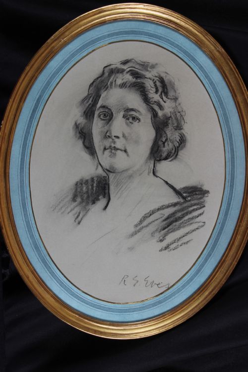fig 3. An oval gilt-framed charcoal portrait drawing of a woman signed by R. G. Eves set against a light blue mount.