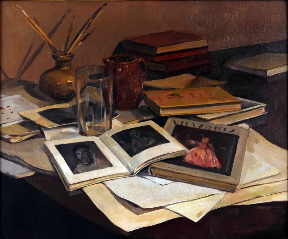 An oil painting depicting an artist studio still life arrangement featuring open art books, loose papers, a glass tumbler, paintbrushes in a pot, and a terracotta jug.