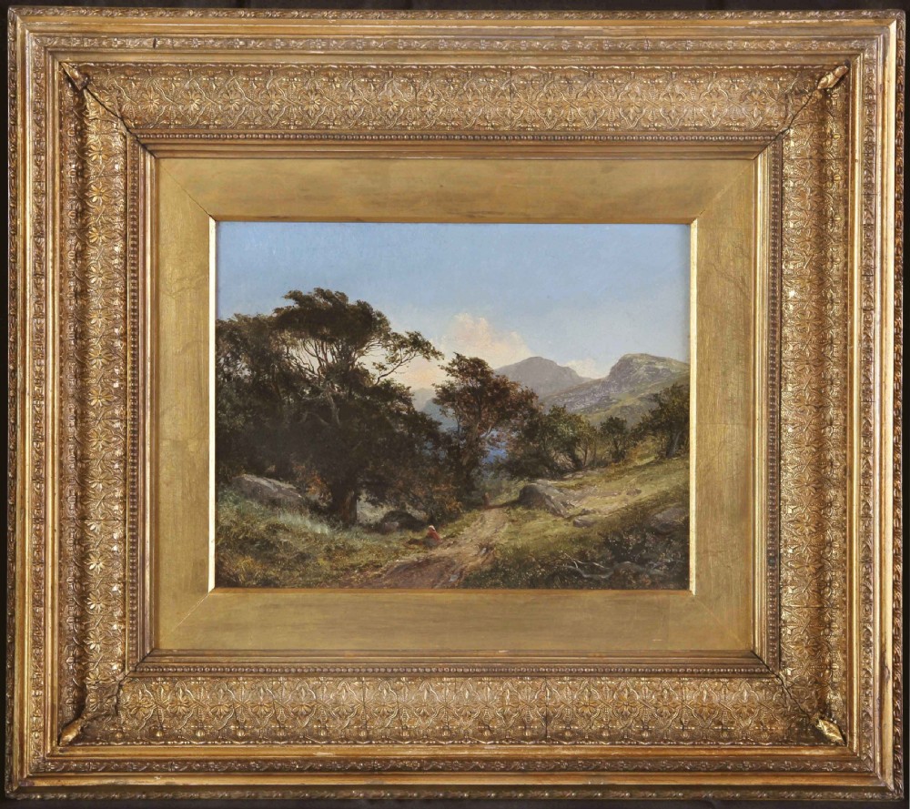 A 19th-century oil landscape painting showing a countryside path framed by mature trees beneath a blue sky, set within an ornate gilded frame.