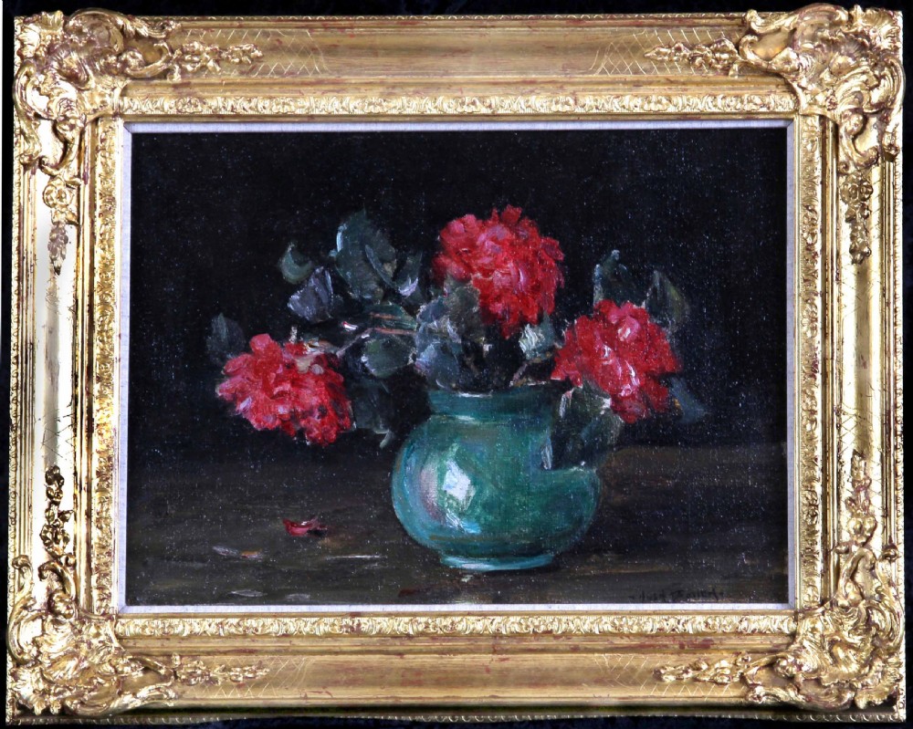 A framed oil painting depicting deep red roses arranged in a green ceramic vase against a dark background, set within an ornate gilt swept frame.