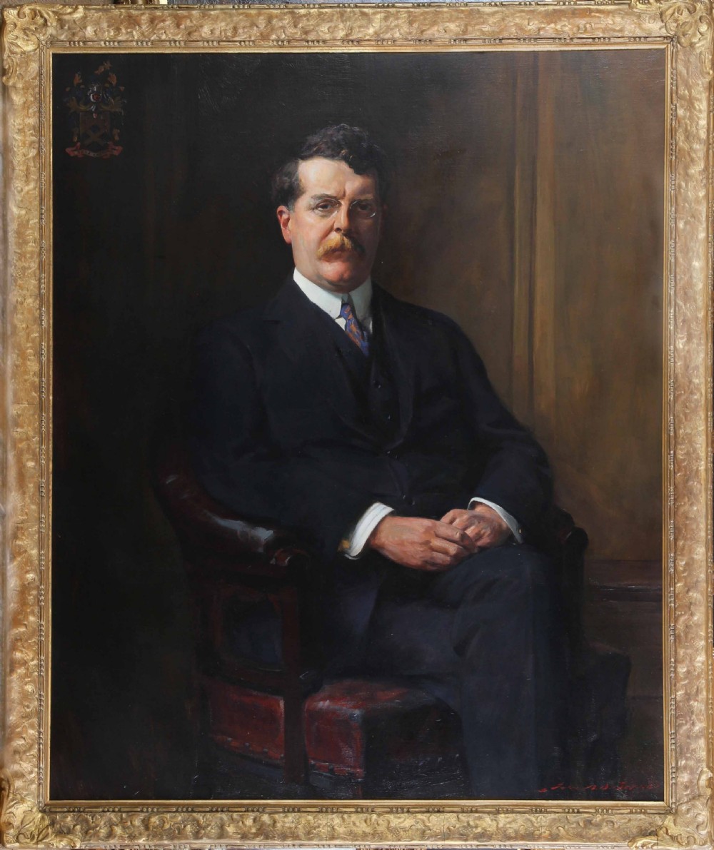 An antique oil painting depicting a seated gentleman wearing a dark suit and spectacles, set within an ornate gilded frame.