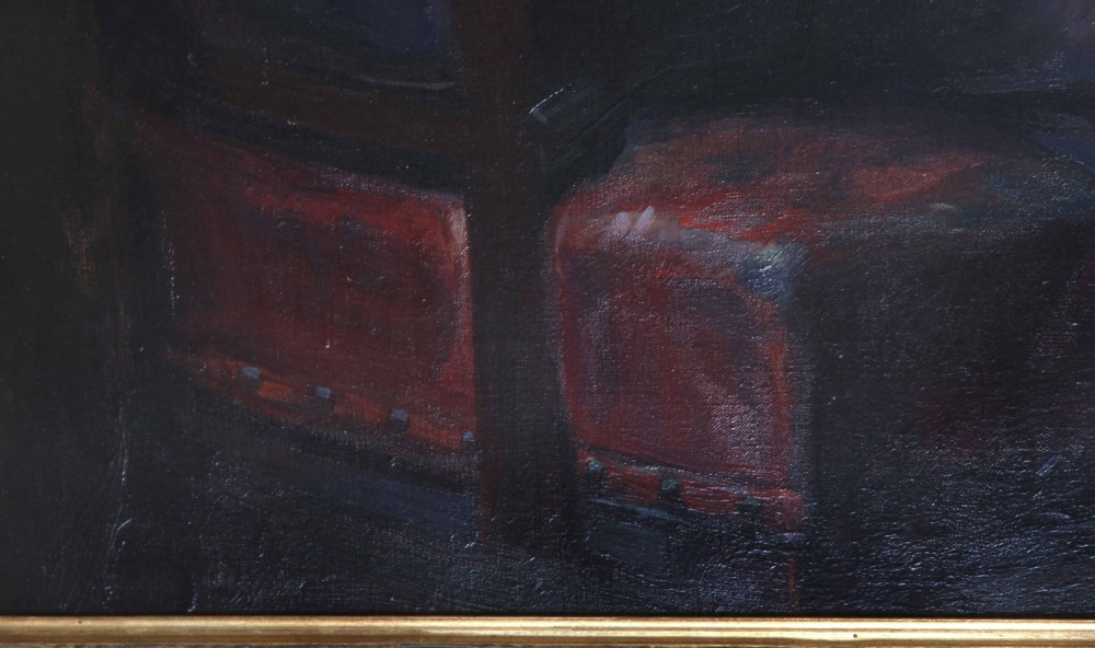 An antique oil painting depicting a seated gentleman wearing a dark suit and spectacles, set within an ornate gilded frame. View V