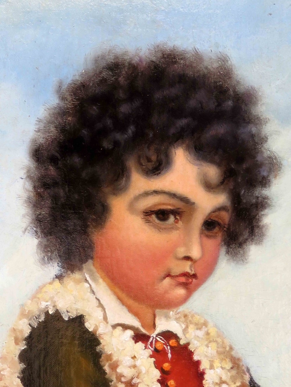 An oil portrait on board depicting a young boy with dark curly hair in traditional attire, framed in a heavily moulded gold gilt frame. View III