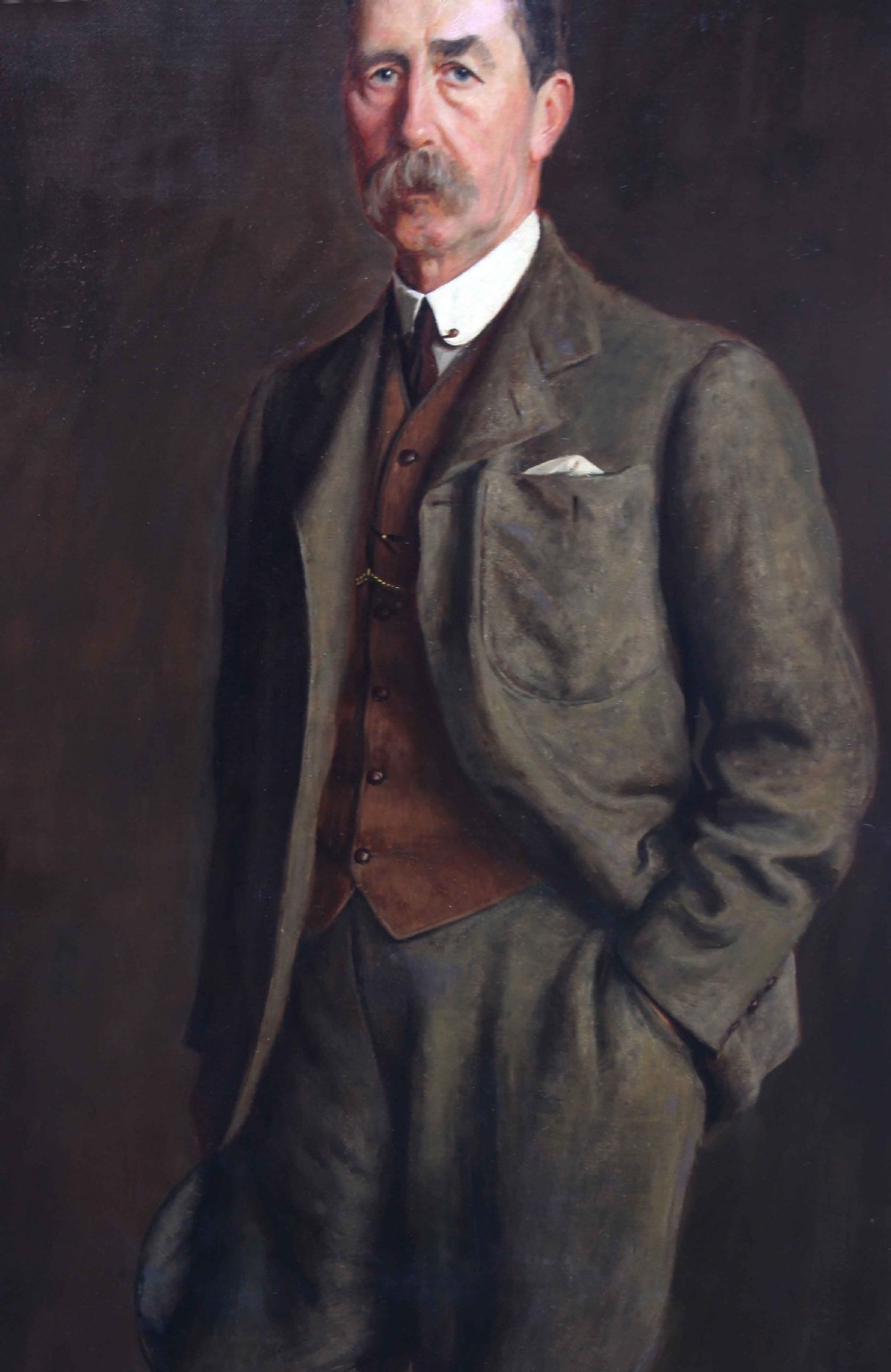 A large framed Edwardian oil portrait painting depicting a standing gentleman in a brown suit against a dark background. View IV
