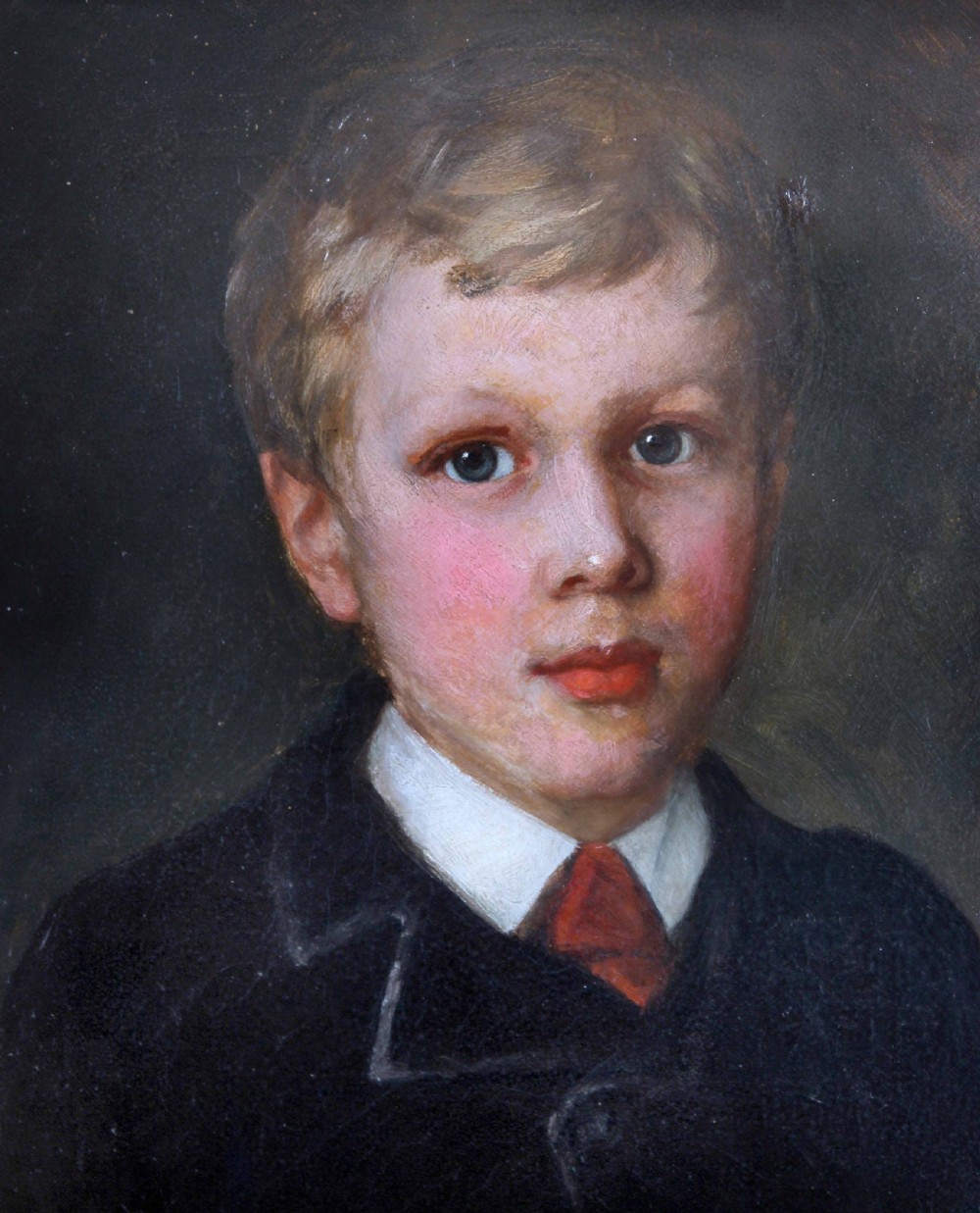 An Edwardian oil painting depicting a young boy in a dark coat, housed inside a decorative gilded frame. View III