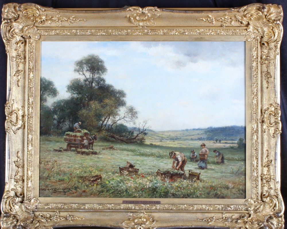 An Edwardian landscape oil painting depicting agricultural workers during harvest, housed in an ornate carved gilt wood frame.