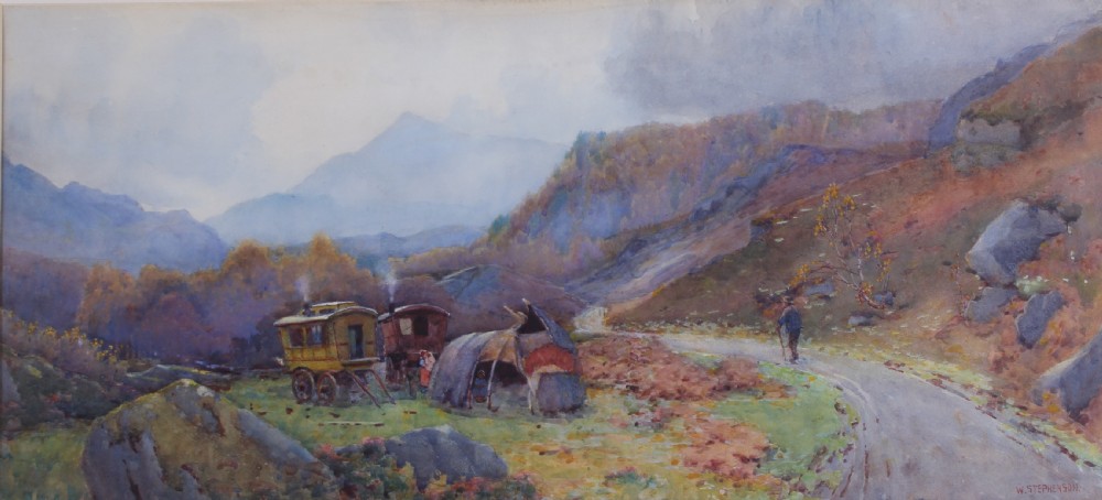 A framed watercolour landscape painting by Willie Stephenson depicting a gypsy encampment with traditional caravans and a tent along a mountain path.