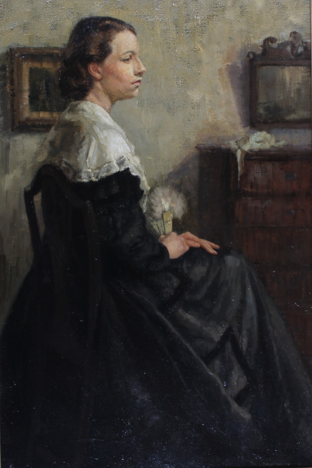A mid-twentieth-century oil painting on canvas depicting a seated woman in profile wearing a dark dress and white lace shawl within an interior setting.
