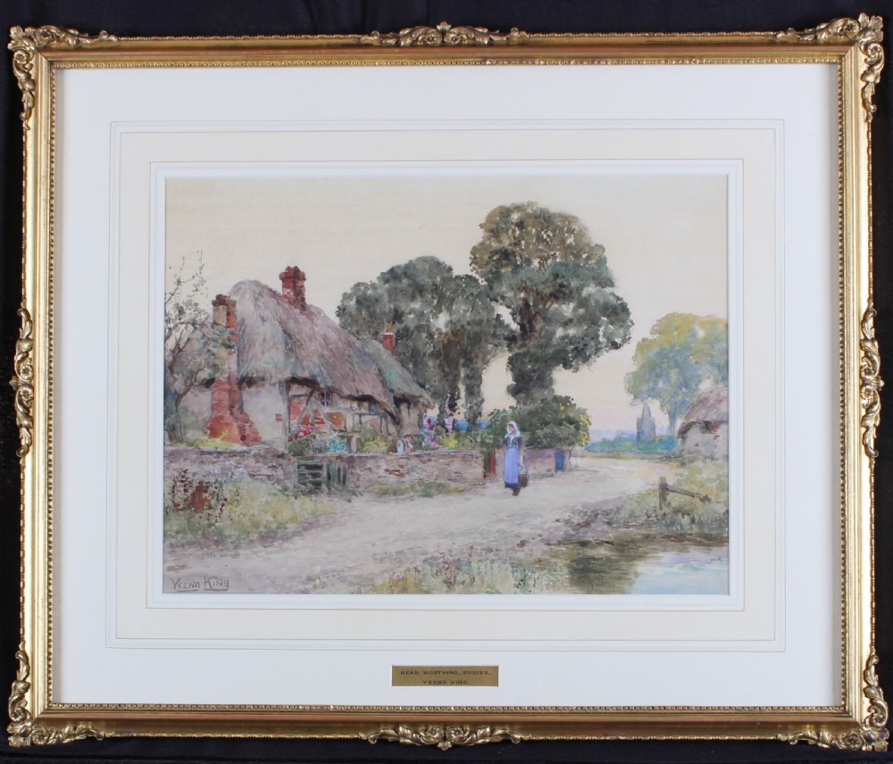 A framed 19th-century watercolour painting depicting a thatched cottage along a rural dirt road in Sussex, presented in an ornate gilt frame.