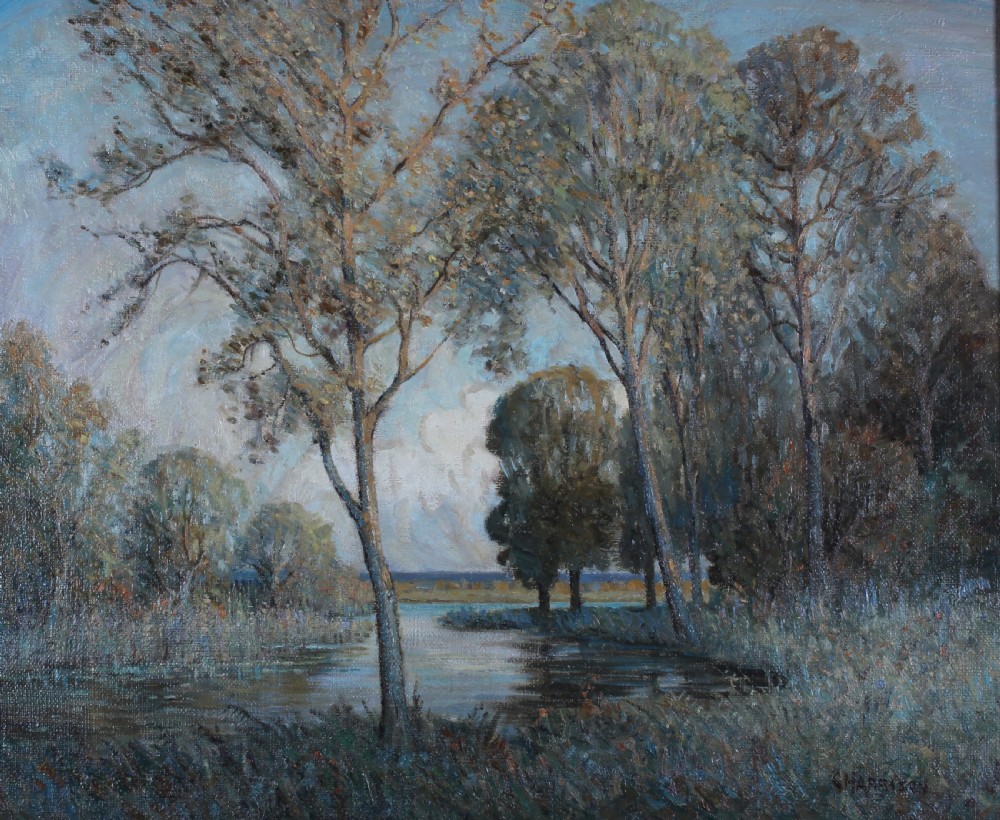 A large impressionistic oil painting depicting a calm lake surrounded by tall leafy trees, set within an ornate gilded frame. View II