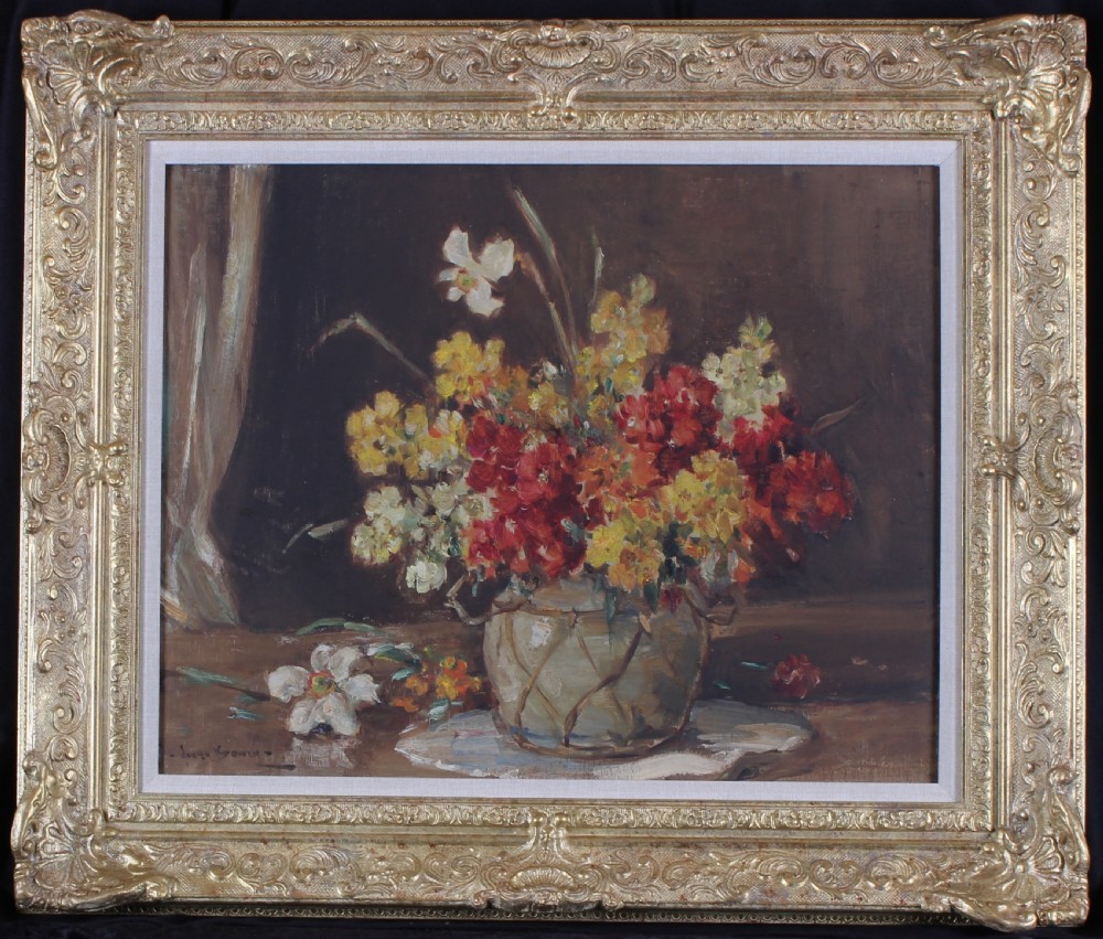 A framed still life oil painting depicting a vase filled with red, yellow, and white spring flowers against a dark backdrop, set inside a heavy ornate gold frame.