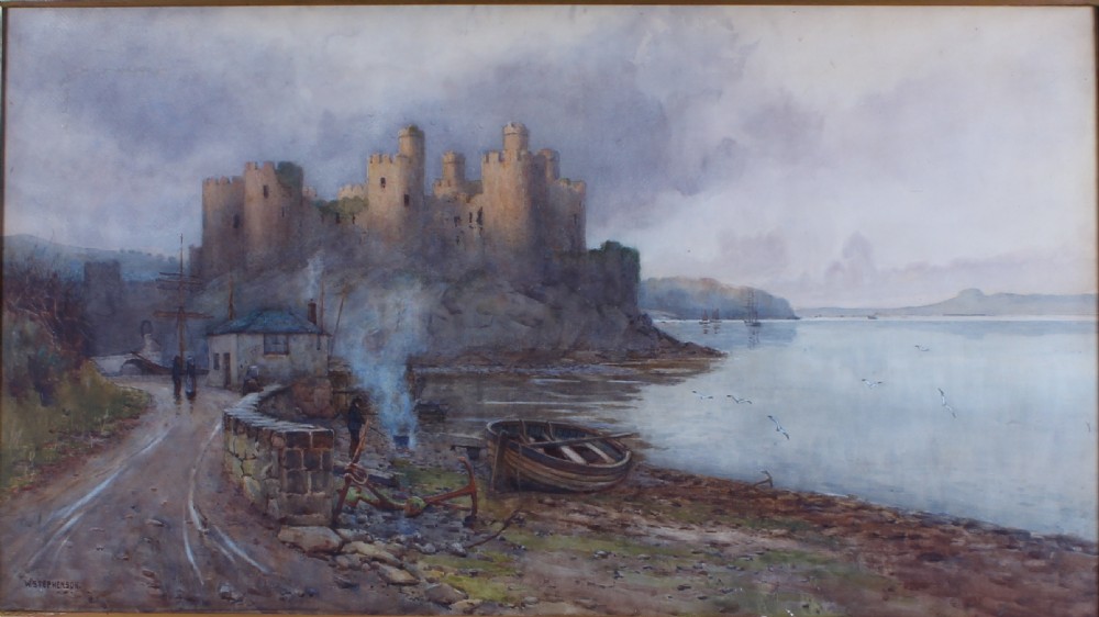 A landscape watercolour painting depicting Conwy Castle on a rocky shore beside a body of water with a small boat and figures in the foreground.