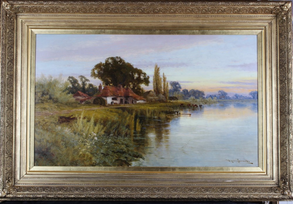 A large framed landscape oil painting depicting a quiet river with a cottage on the bank and cattle standing near the water under a soft evening sky.