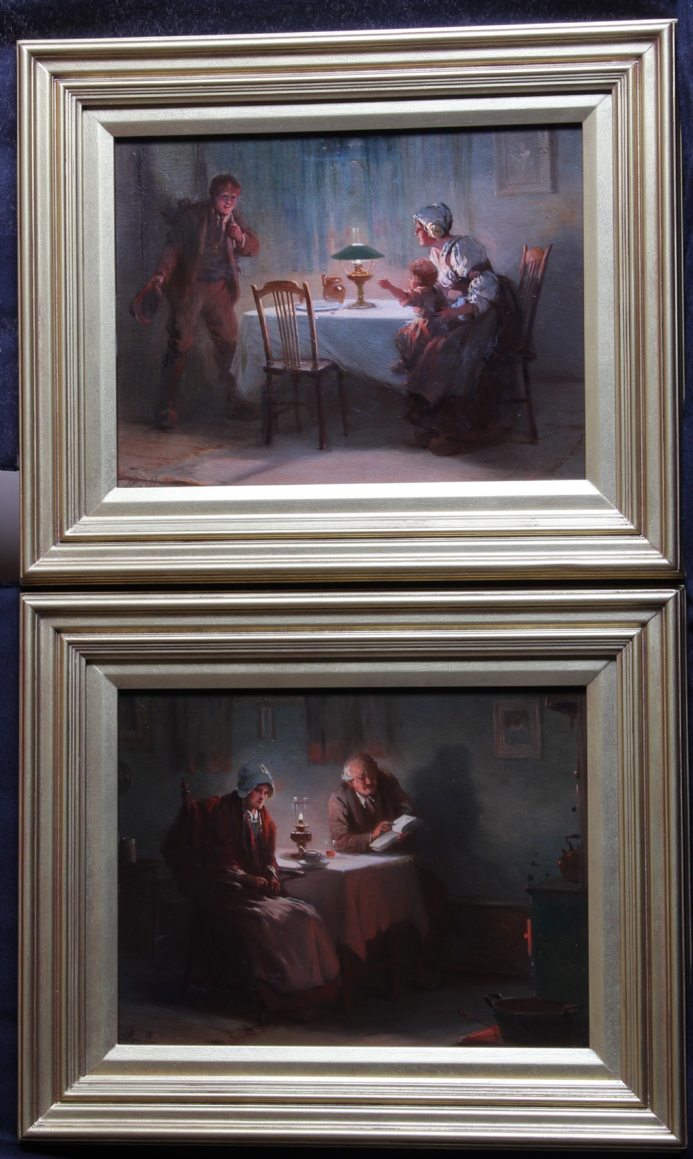 A pair of framed oil paintings depicting lamplit domestic scenes inside traditional 19th-century homes.