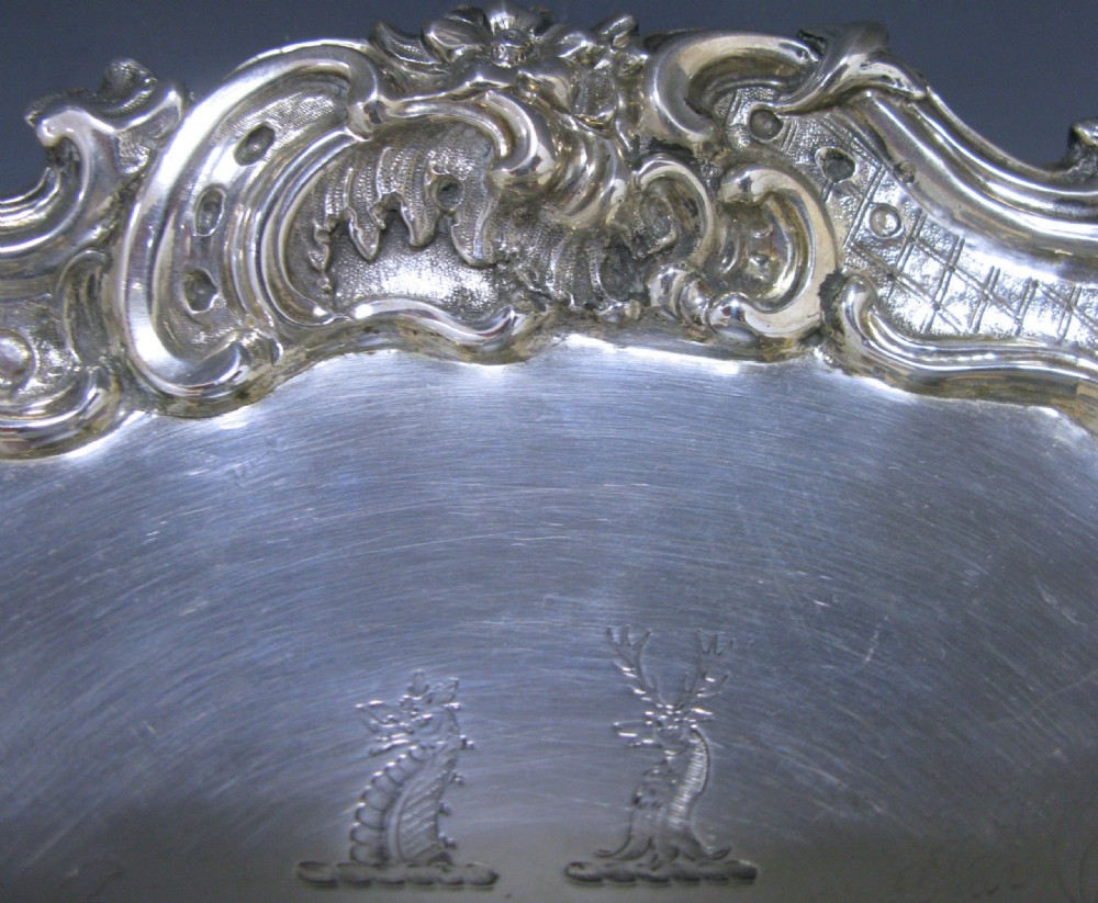 A circular Victorian sterling silver salver featuring a moulded scroll and floral border around an engraved central landscape scene. View III