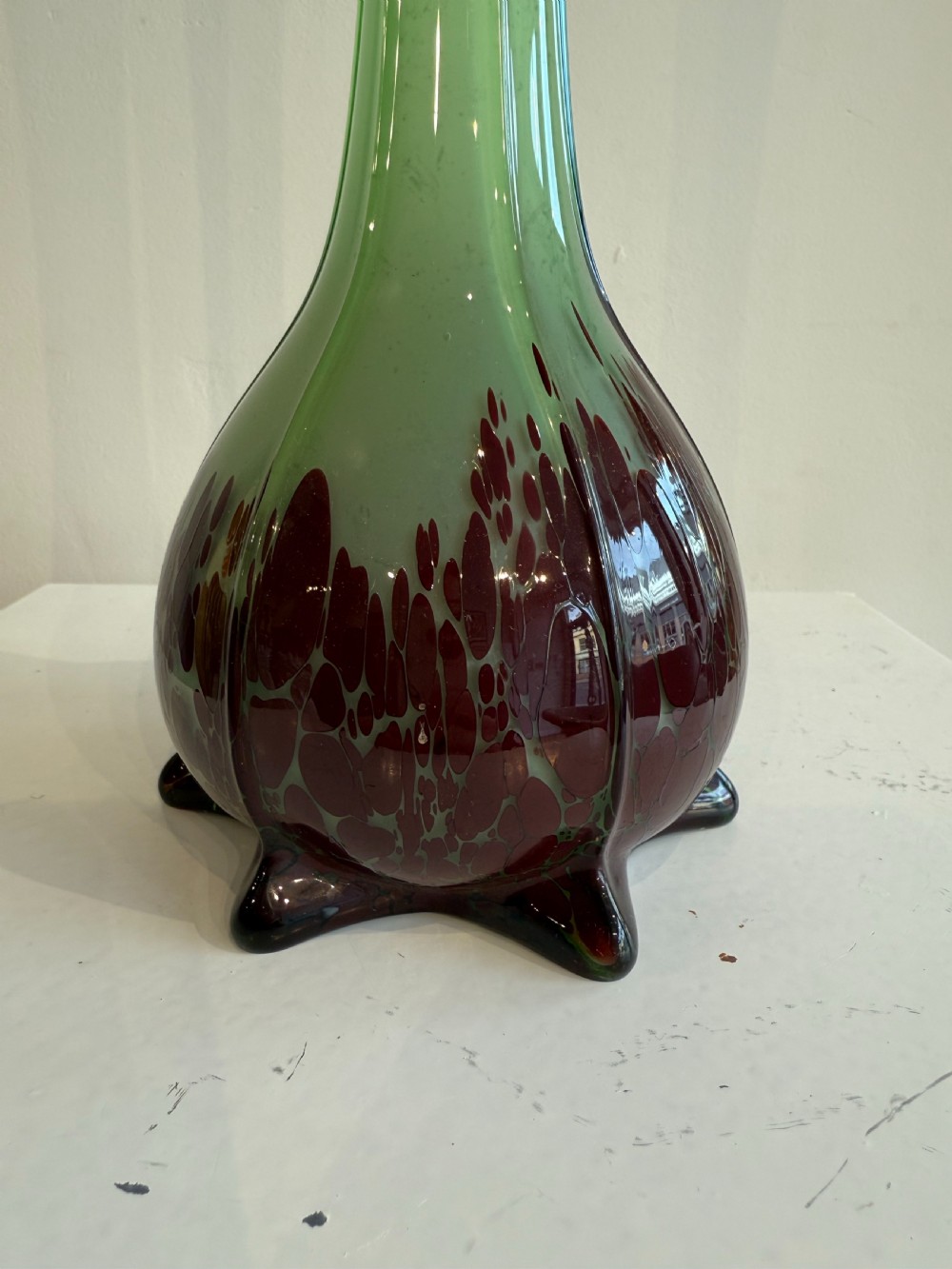 A pair of tall French hand-blown art glass vases featuring slender green necks resting on bulbous burgundy spattered bases with pinched feet. View VII