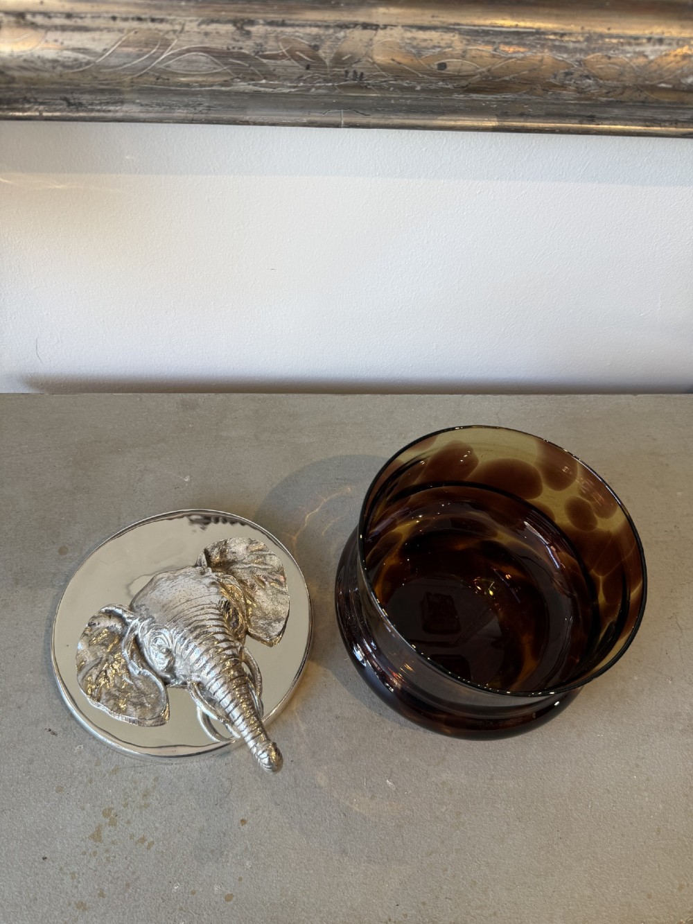 A circular faux tortoiseshell bowl with a polished silver-coloured metal lid featuring a sculpted elephant head in full relief. View IV