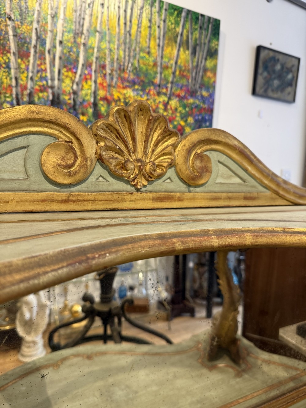 A Venetian Rococo style green painted and giltwood console table featuring carved dolphin supports, spiral columns, serpentine shelves, and mirrored back panels. View II
