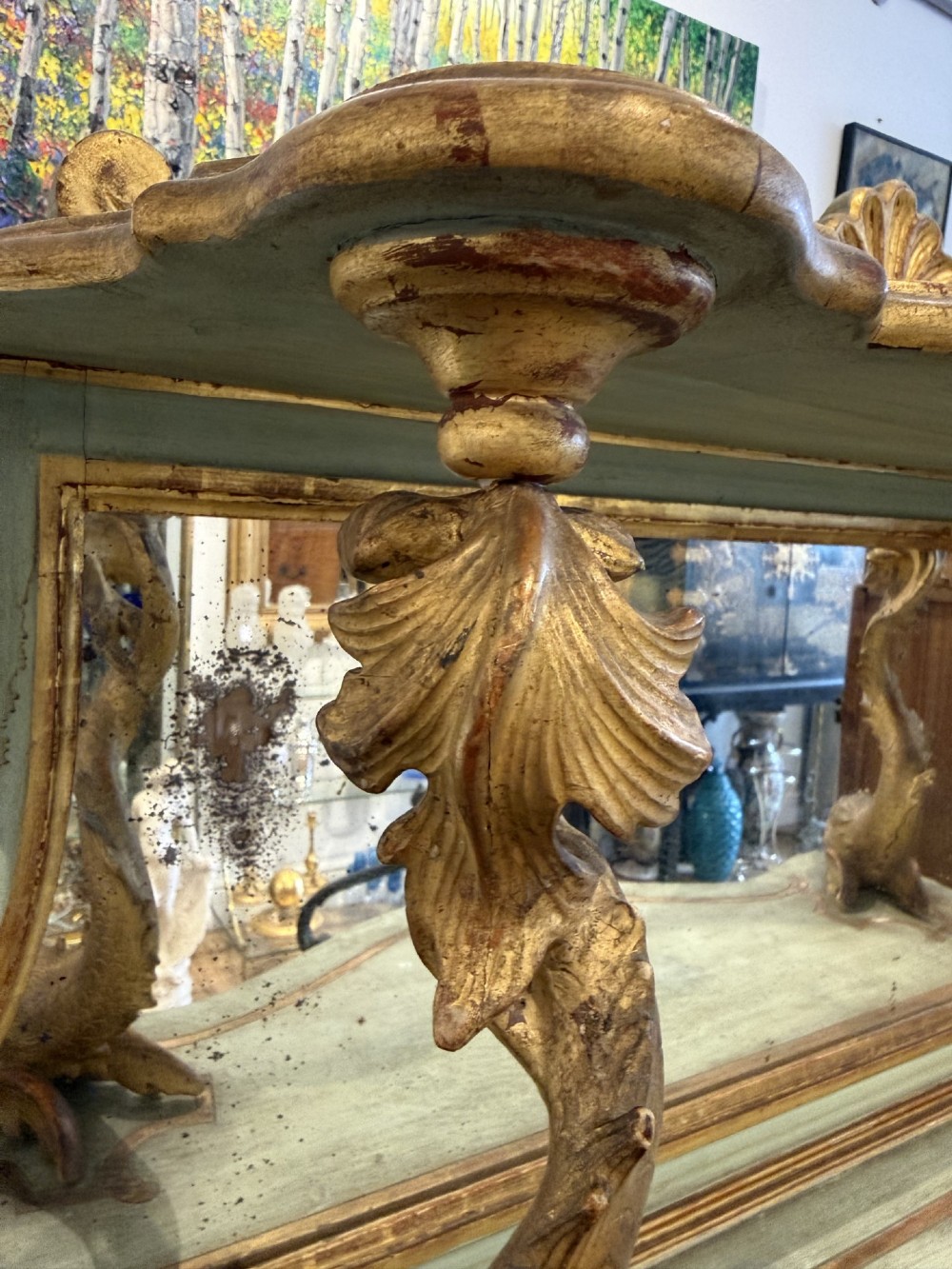 A Venetian Rococo style green painted and giltwood console table featuring carved dolphin supports, spiral columns, serpentine shelves, and mirrored back panels. View IV