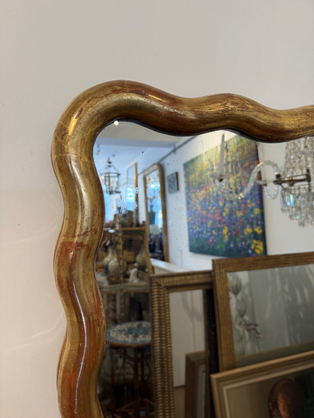 A tall full-length rectangular mirror featuring a gilded gold frame with a continuous wavy undulating edge. View VI
