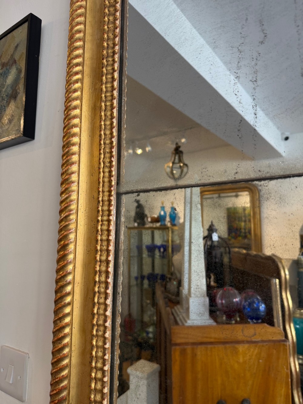 A tall rectangular antique French wall mirror featuring a gold gilded frame with rounded upper corners and textured ripple moulding. View III