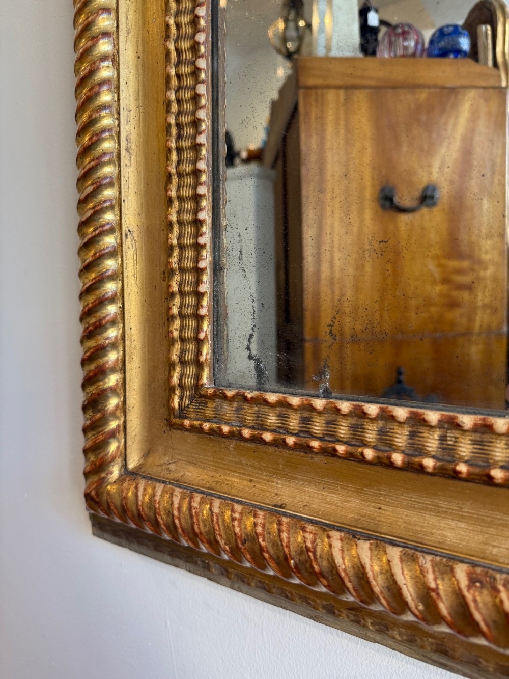 A tall rectangular antique French wall mirror featuring a gold gilded frame with rounded upper corners and textured ripple moulding. View IV