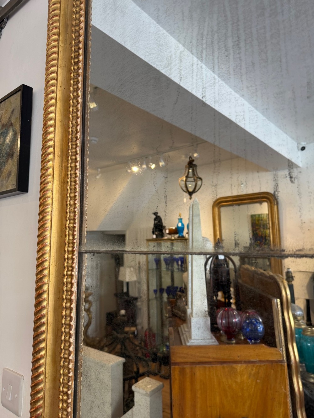 A tall rectangular antique French wall mirror featuring a gold gilded frame with rounded upper corners and textured ripple moulding. View VI