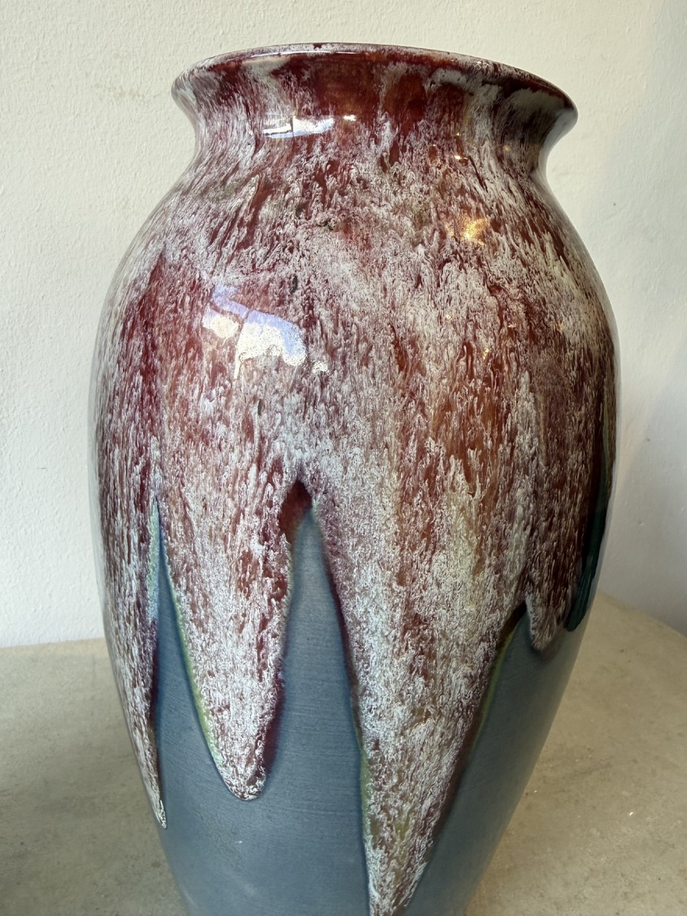 A pair of glazed ceramic art pottery vases featuring a running burgundy and white speckled drip glaze over a matte slate blue base. View III