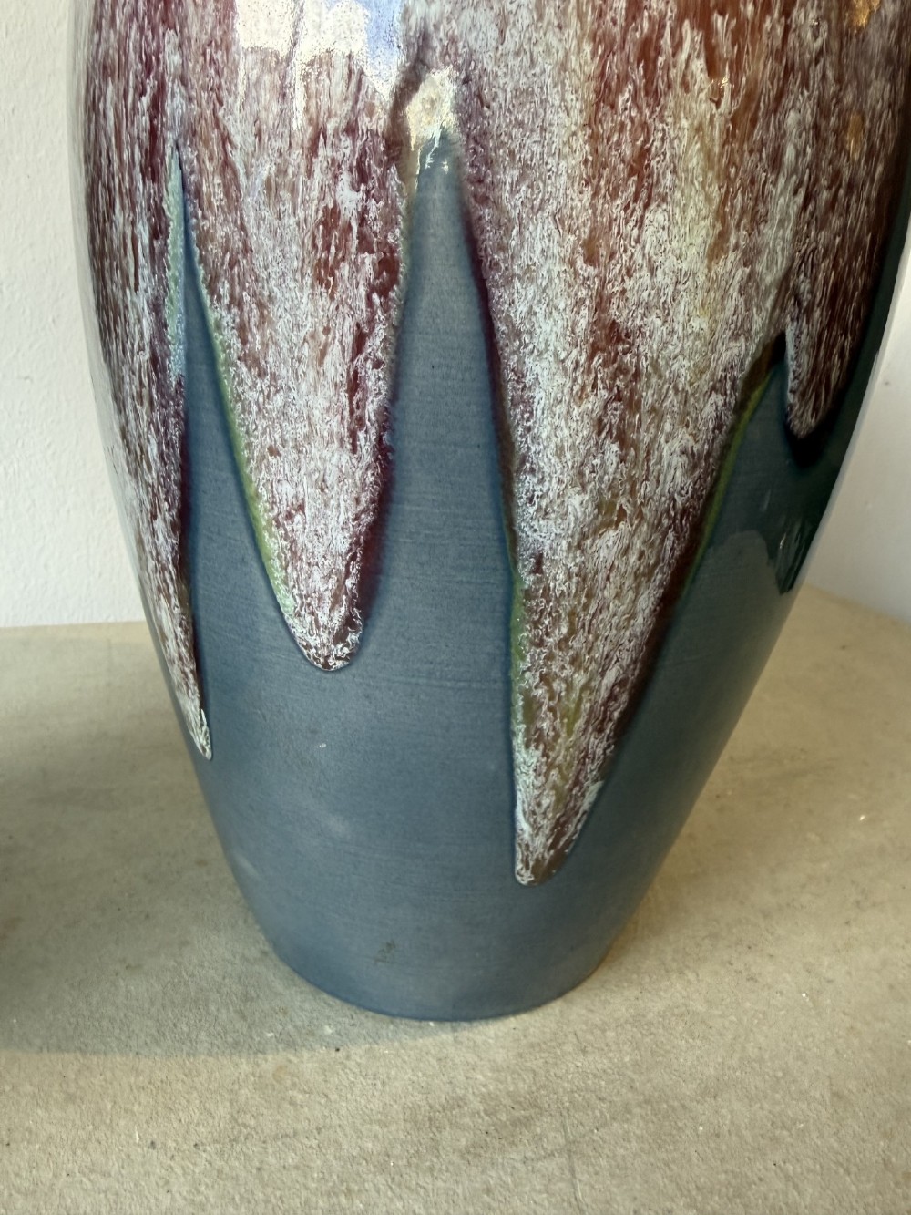 A pair of glazed ceramic art pottery vases featuring a running burgundy and white speckled drip glaze over a matte slate blue base. View IV