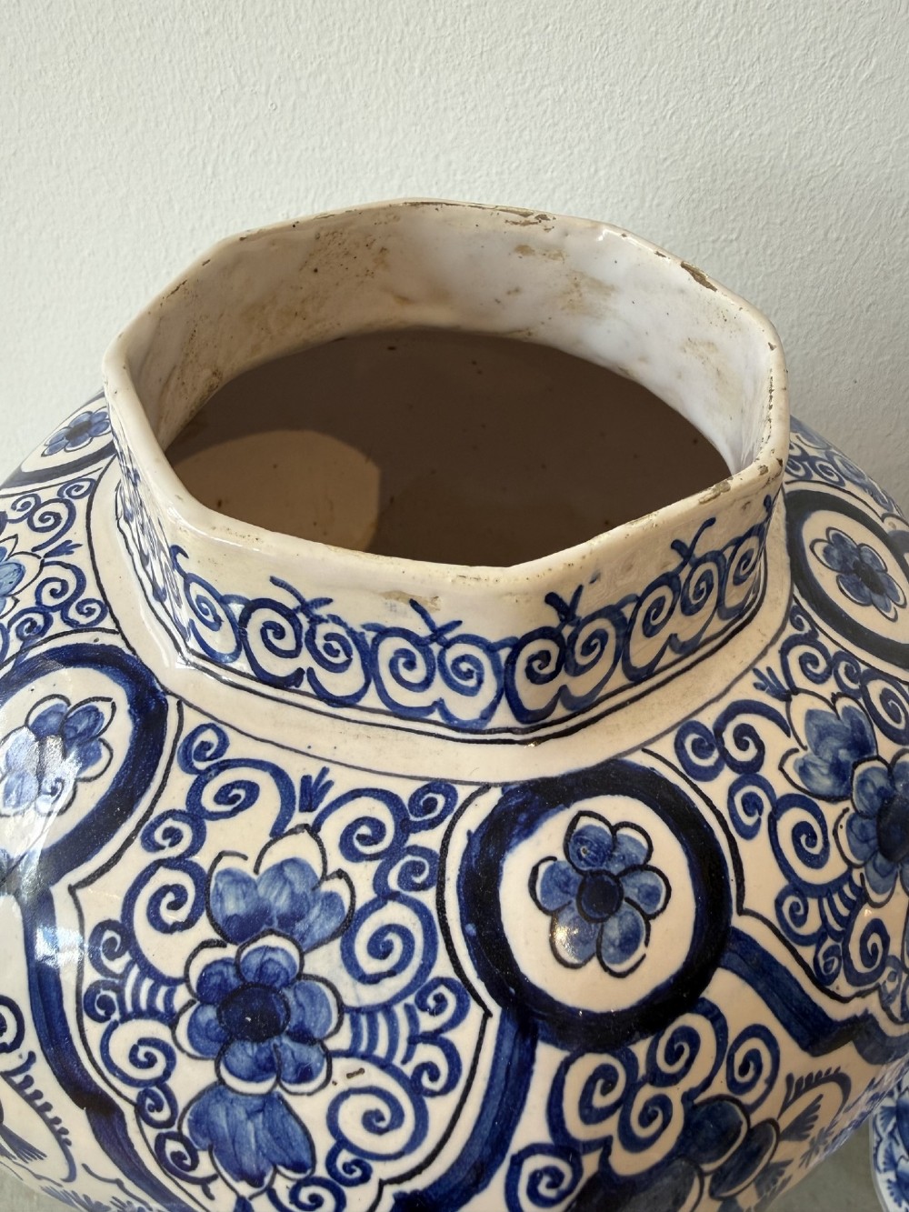 A pair of octagonal tin-glazed earthenware lidded vases decorated with hand-painted blue floral patterns on a white ground, topped with pointed finials. View IV