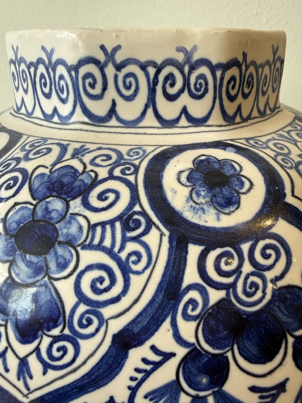 A pair of octagonal tin-glazed earthenware lidded vases decorated with hand-painted blue floral patterns on a white ground, topped with pointed finials. View VII
