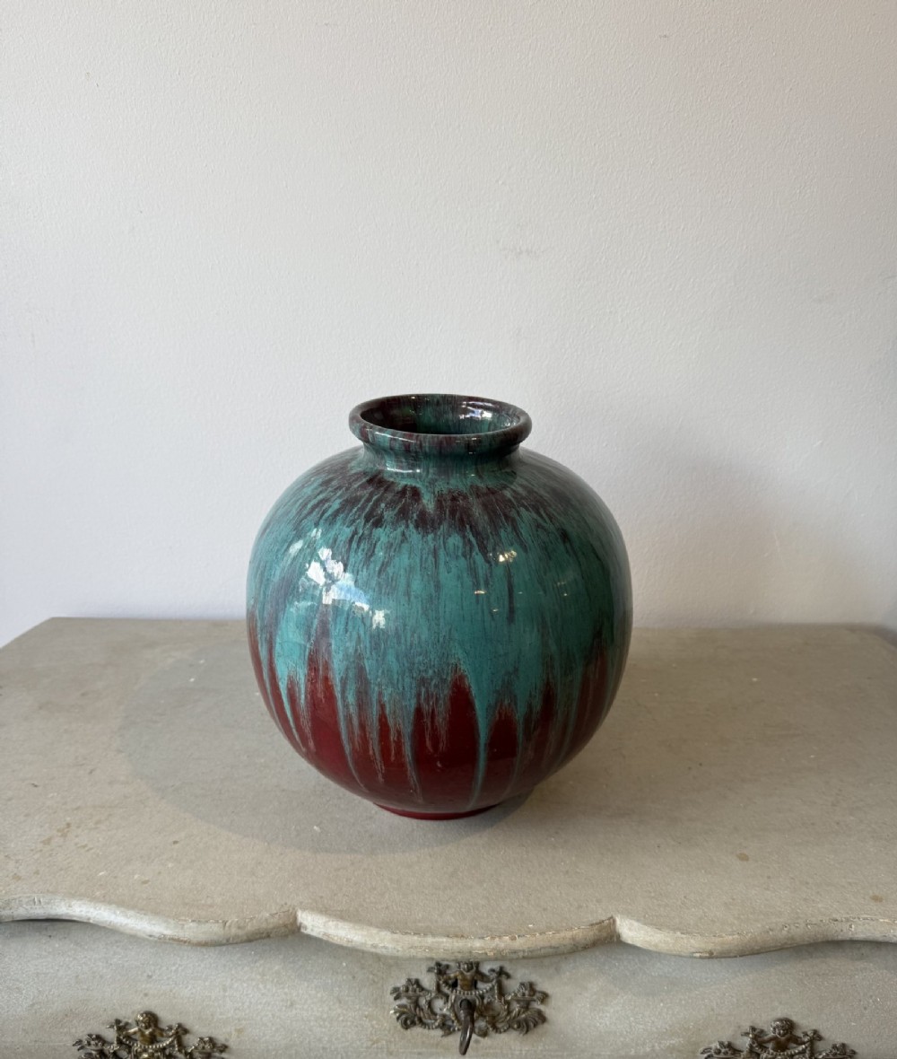 A large bulbous French ceramic vase featuring a dripped turquoise and deep red glossy glaze finish.
