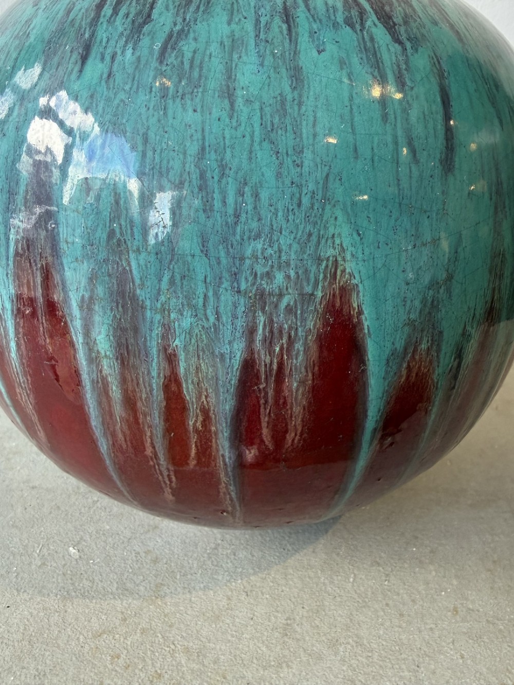 A large bulbous French ceramic vase featuring a dripped turquoise and deep red glossy glaze finish. View III