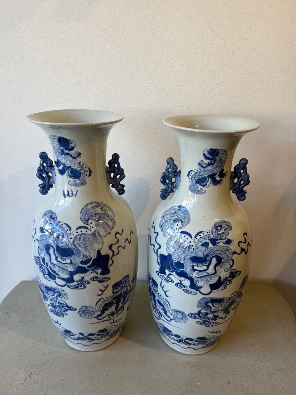 A pair of large Chinese porcelain baluster vases painted in cobalt blue underglaze with guardian lion motifs and decorative scrolled handles. View II