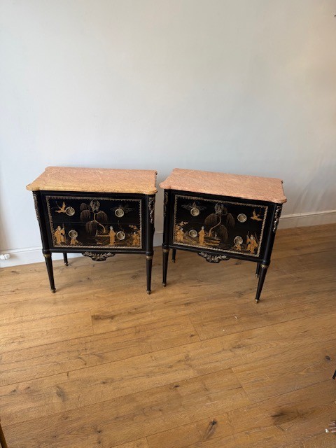 A pair of black lacquered Louis XVI style commodes featuring gold gilt Chinoiserie landscapes, marble tops, and tapered fluted legs. View II