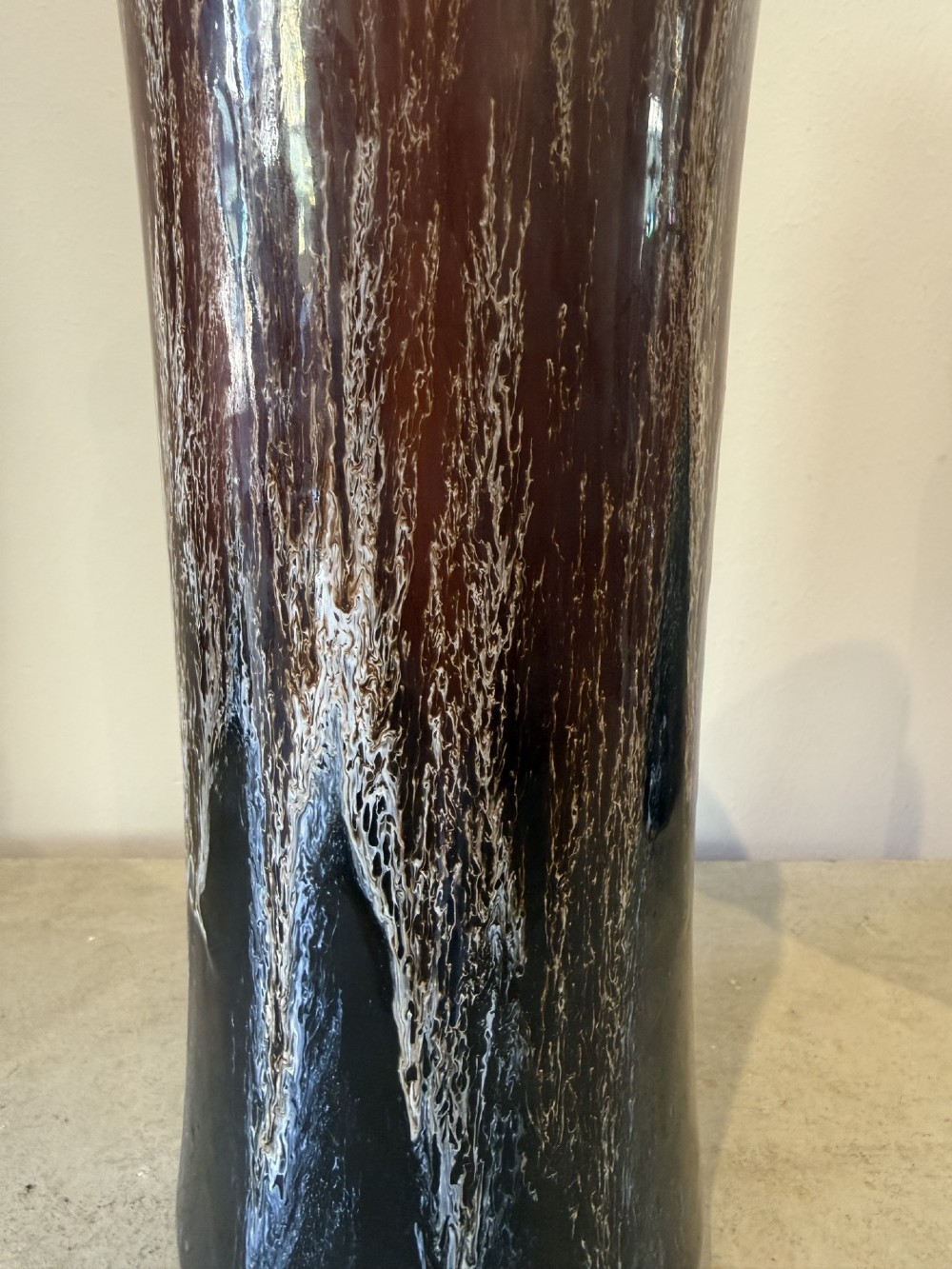A pair of tall cylindrical antique ceramic vases featuring a dark brown and black drip glaze finish with brass mounts at the base. View IV