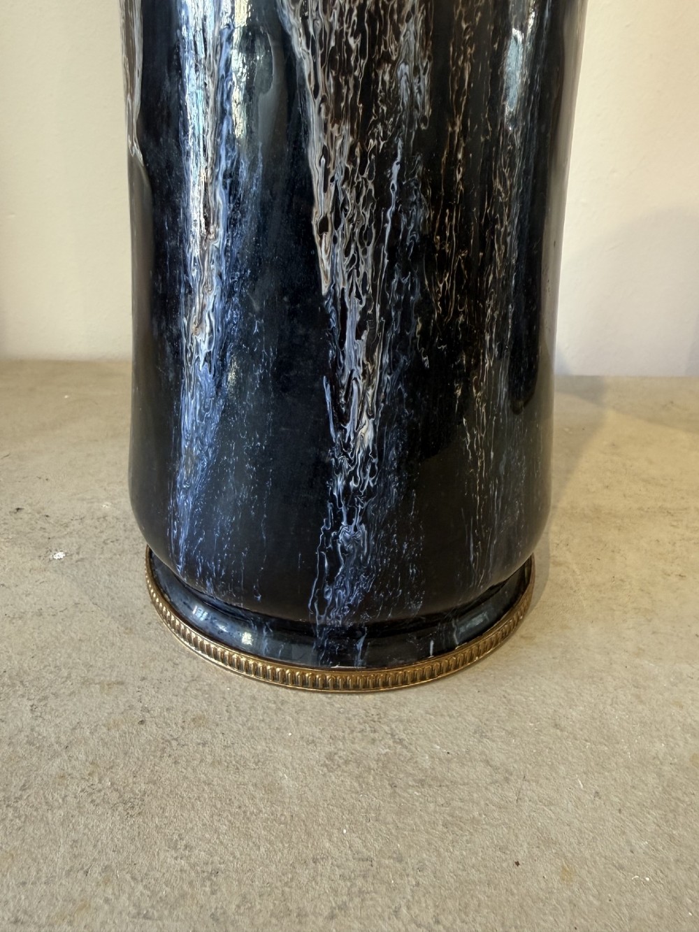 A pair of tall cylindrical antique ceramic vases featuring a dark brown and black drip glaze finish with brass mounts at the base. View V