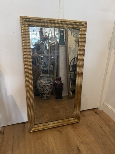 A large rectangular 19th-century wall mirror featuring a textured gold ripple-moulded frame.