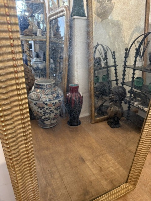 A large rectangular 19th-century wall mirror featuring a textured gold ripple-moulded frame. View IV