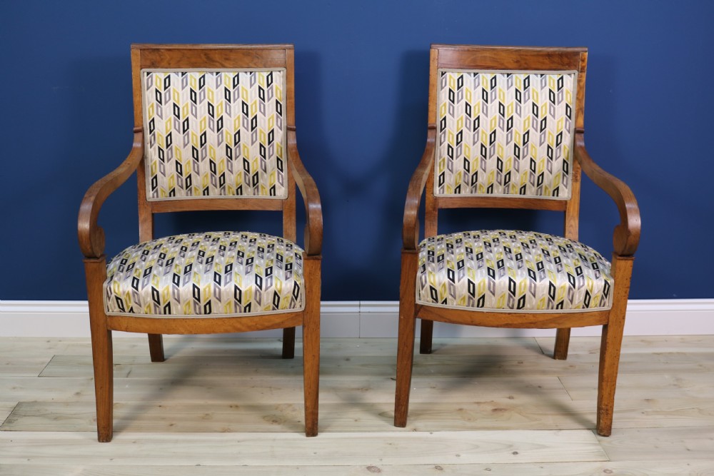 A pair of nineteenth-century French walnut fauteuils featuring scrolled armrests, raked backs, and patterned geometric upholstery. View IX