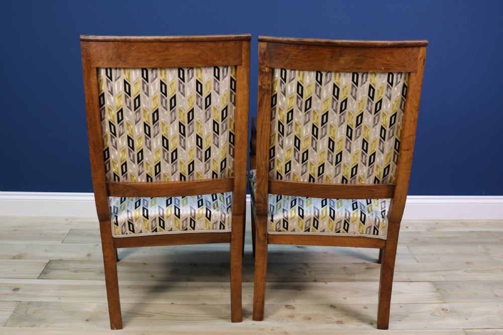 A pair of nineteenth-century French walnut fauteuils featuring scrolled armrests, raked backs, and patterned geometric upholstery. View XII