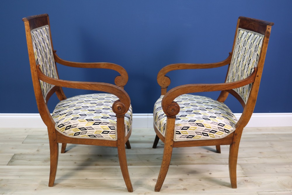 A pair of nineteenth-century French walnut fauteuils featuring scrolled armrests, raked backs, and patterned geometric upholstery. View XIII