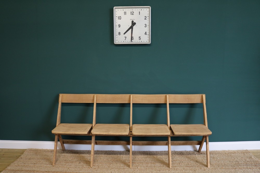 A four-seat antique folding oak bench with integrated iron hinges and sloped backrests positioned on a woven rug. View IX