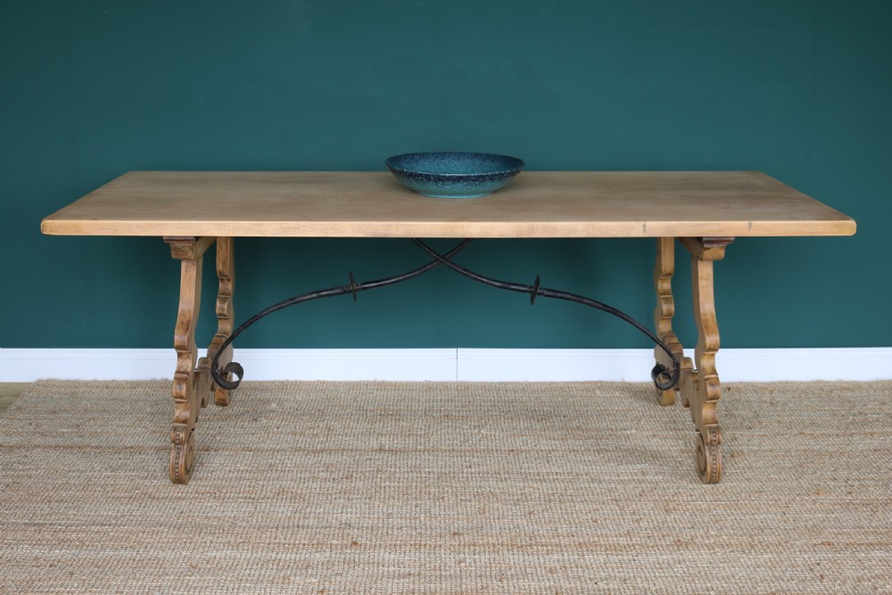 A solid walnut dining table featuring a rectangular plank top, scrolled lyre-shaped trestle legs, and curved wrought iron stretchers. View VIII