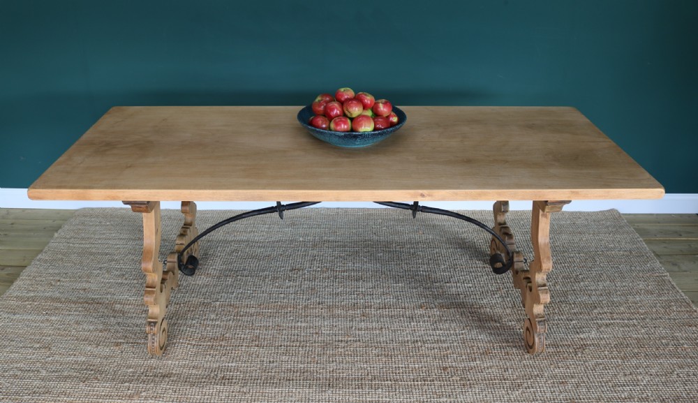 A solid walnut dining table featuring a rectangular plank top, scrolled lyre-shaped trestle legs, and curved wrought iron stretchers. View XII