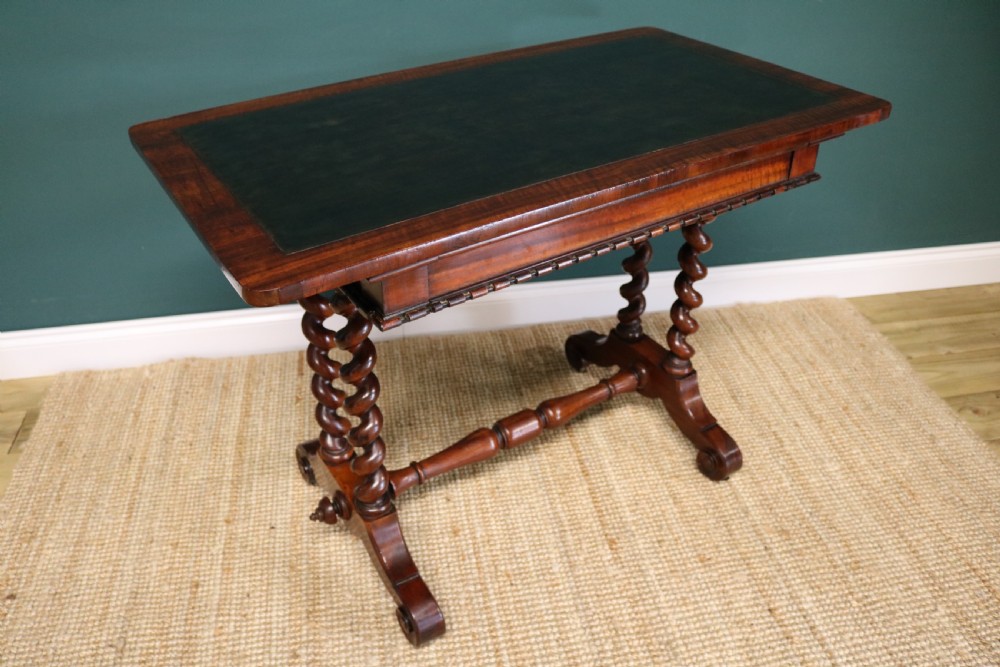 A William IV Goncalo Alves writing table featuring a dark green leather inset top, twin barley twist leg supports, and a central turned stretcher. View II