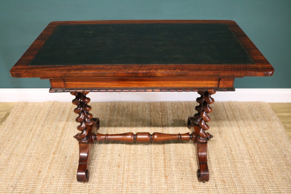 A William IV Goncalo Alves writing table featuring a dark green leather inset top, twin barley twist leg supports, and a central turned stretcher. View III