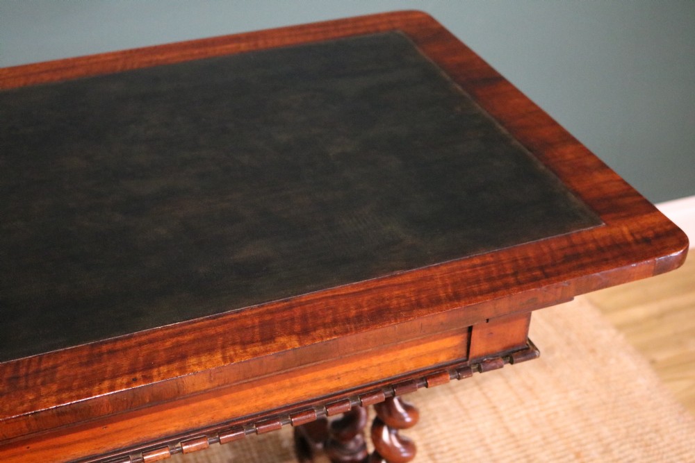 A William IV Goncalo Alves writing table featuring a dark green leather inset top, twin barley twist leg supports, and a central turned stretcher. View VII