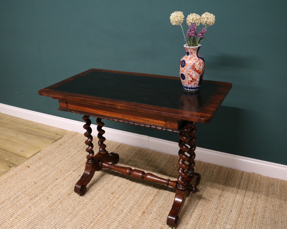 A William IV Goncalo Alves writing table featuring a dark green leather inset top, twin barley twist leg supports, and a central turned stretcher. View IX
