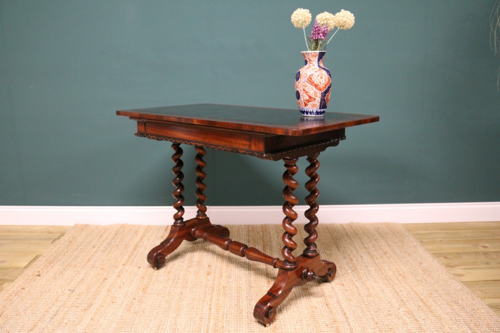 A William IV Goncalo Alves writing table featuring a dark green leather inset top, twin barley twist leg supports, and a central turned stretcher. View XI
